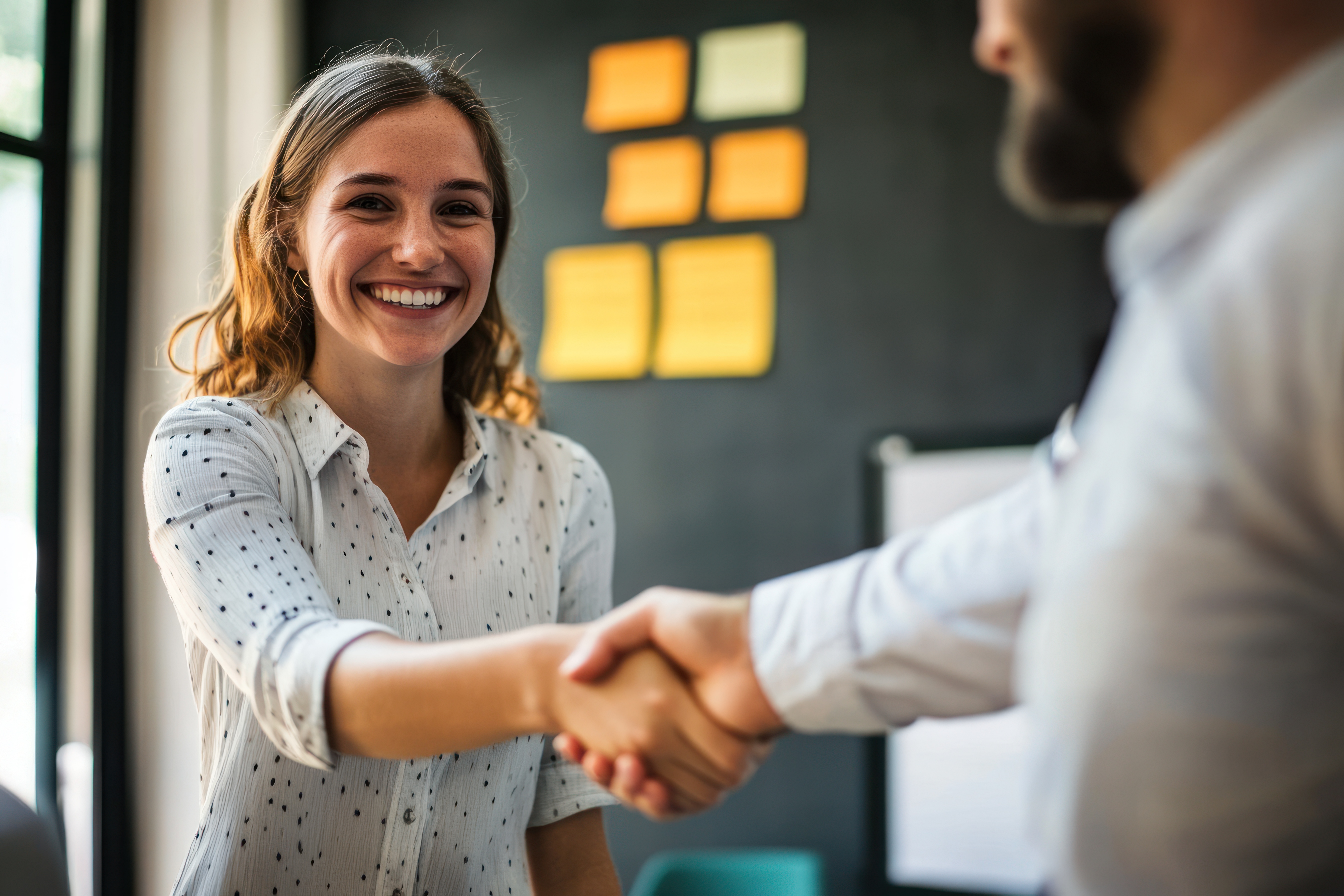 Smiling Woman Shaking Hands with Man
